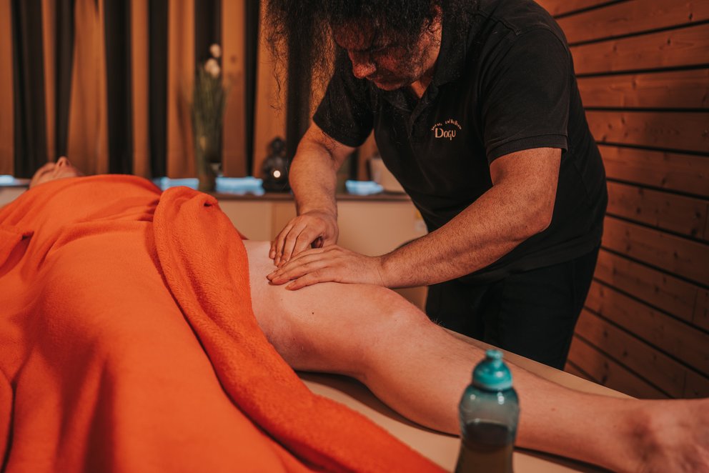Person erhält Massage in Wellnessumgebung. Das Bild zeigt eine Person, die in einer Wellness-Umgebung eine Massage erhält.