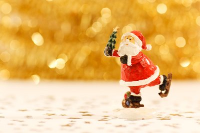 Das Bild zeigt eine kleine, festliche Weihnachtsmann, die auf dem Eis tanzt. 