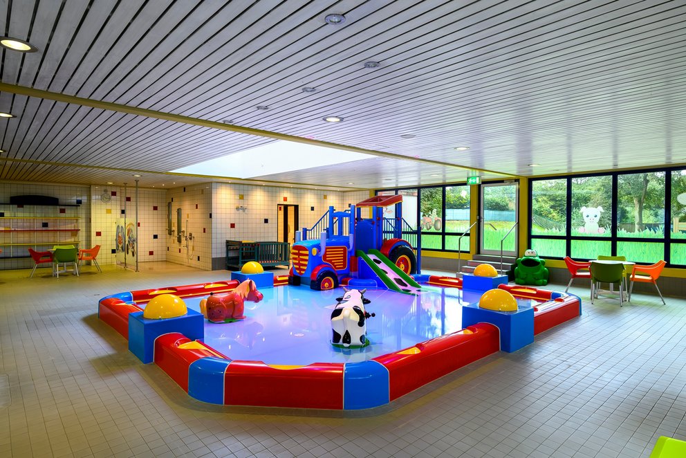 Großer Spielraum mit Wasser- und Trockenrutsche. Großer Indoor-Spielbereich mit einer Rutsche und einer Wasserrutsche, ideal für Kinder zum Spielen und Toben.