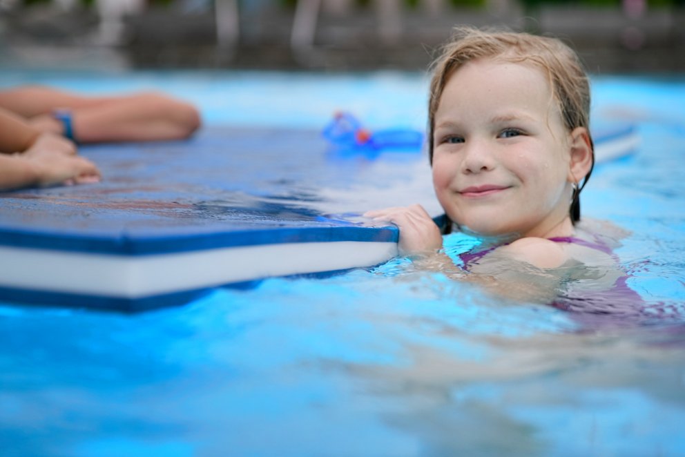 Junges Mädchen im Wasser. Ein junges Mädchen schwimmt fröhlich in einem klaren Pool.