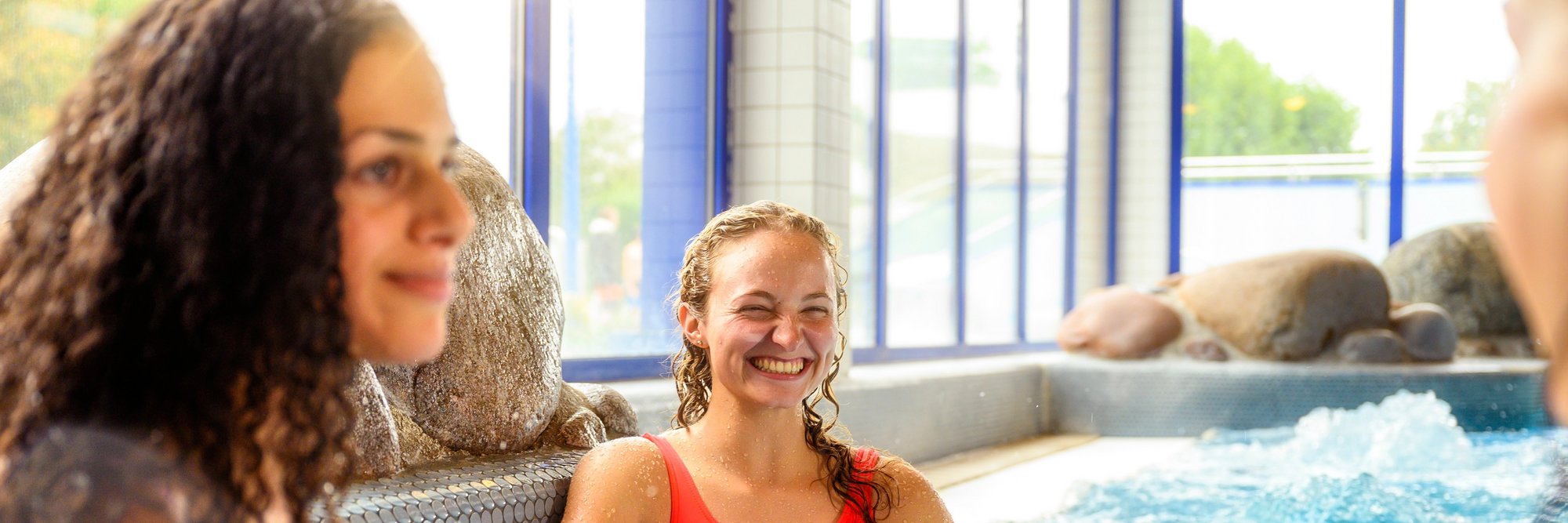 Frauen im Innenbereich eines Solebeckens. Drei Frauen in Badeanzügen stehen im Solebecken eines Hallenbades.