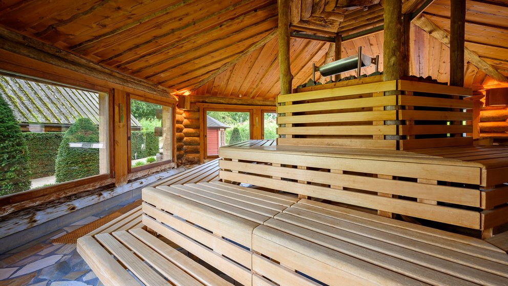 Gemütliche Sauna aus Holz. Eine Holzsauna mit einem Holzfußboden, die eine gemütliche und entspannende Atmosphäre ausstrahlt.