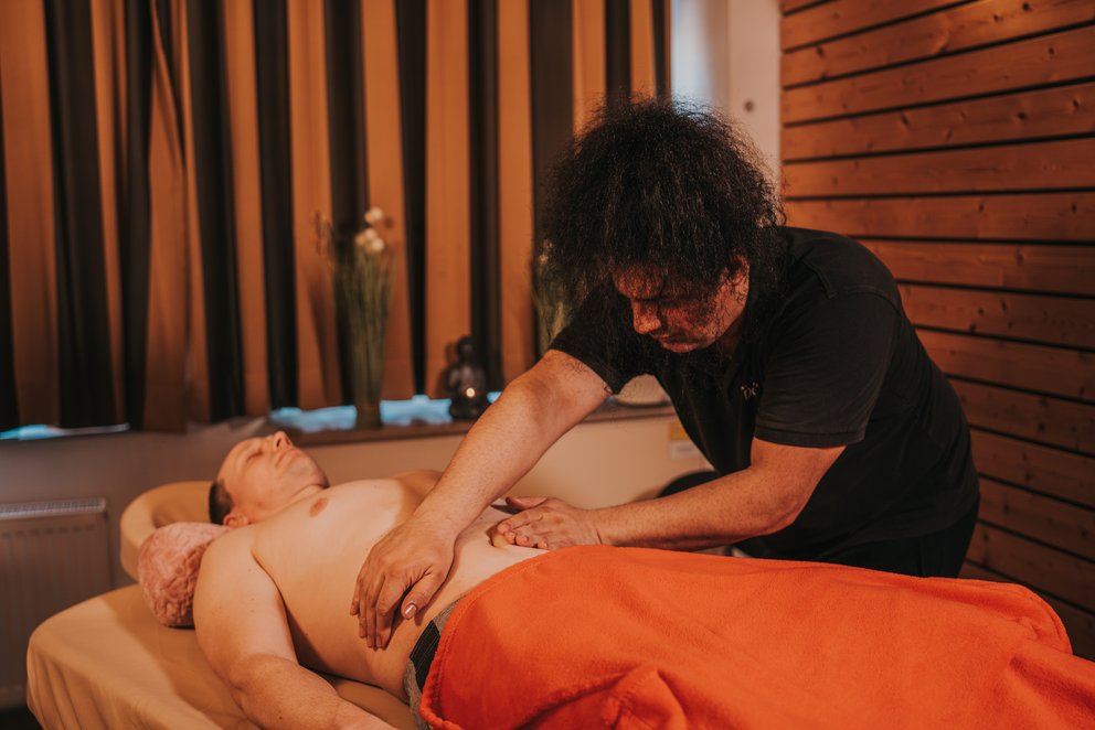Person erhält Massage in Wellnessumgebung. Das Bild zeigt eine Person, die in einer Wellness-Umgebung eine Massage erhält.