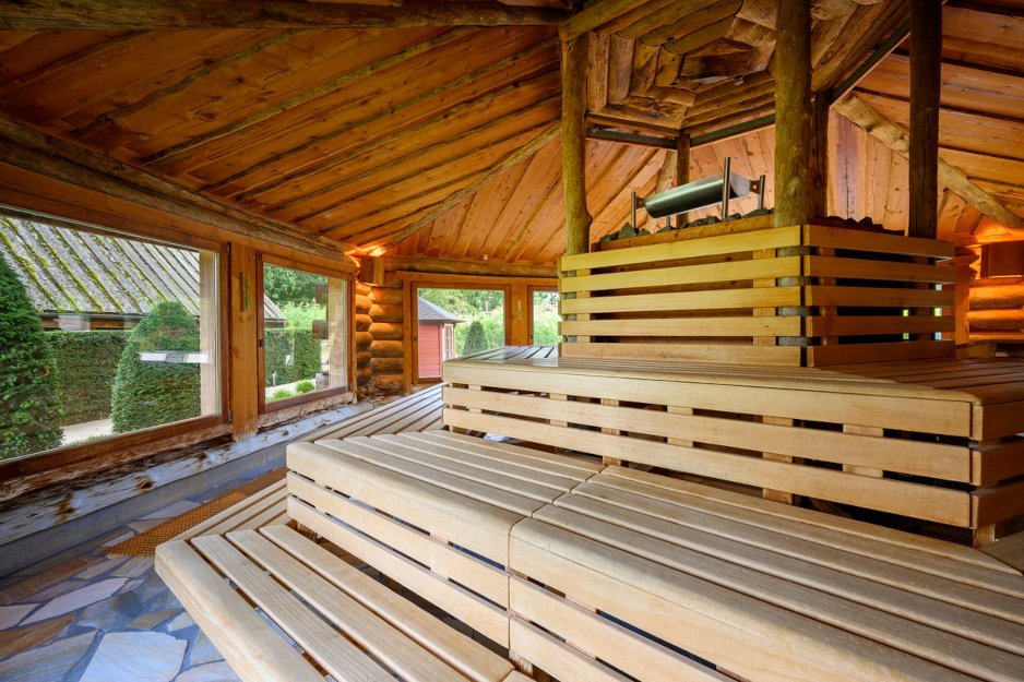 Innenansicht einer Sauna mit Holzbänken. Das Bild zeigt das Innere einer Sauna mit großzügig angeordneten Bänken aus Holz.