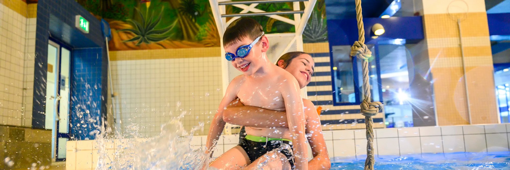 Kinder spielen fröhlich in einem Schwimmbecken.