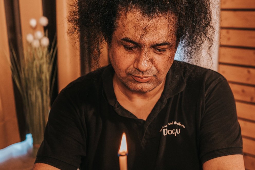 Masseur bei der konzentrierten Massagebehandlung. Das Bild zeigt einen Masseur, der sich konzentriert, während er eine Massage durchführt.