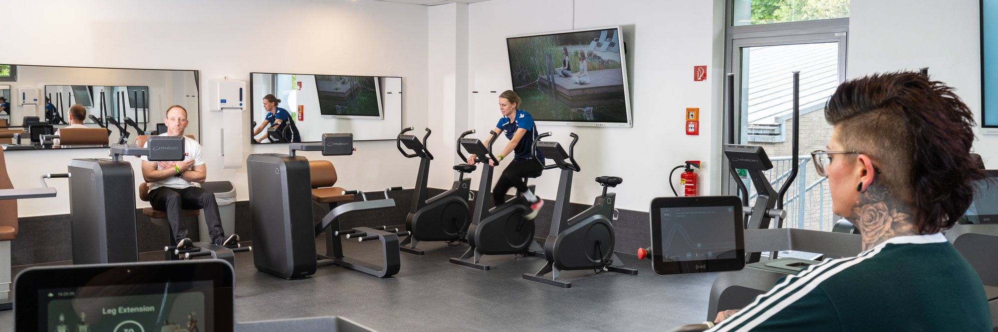 Frau sitzt an einem Fitnessgerät 